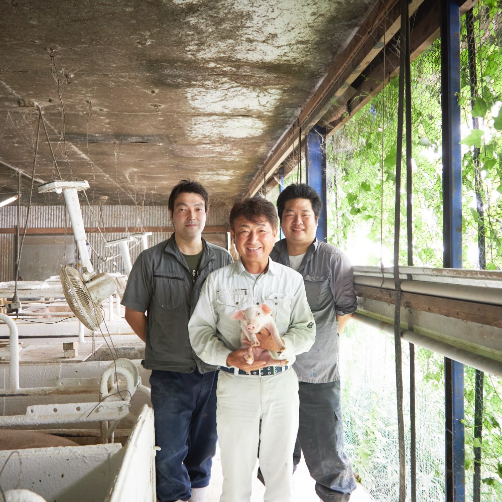土井社長(中央)と豚舎担当の田中栄伍さん(左)、村上宏樹さん(右)
